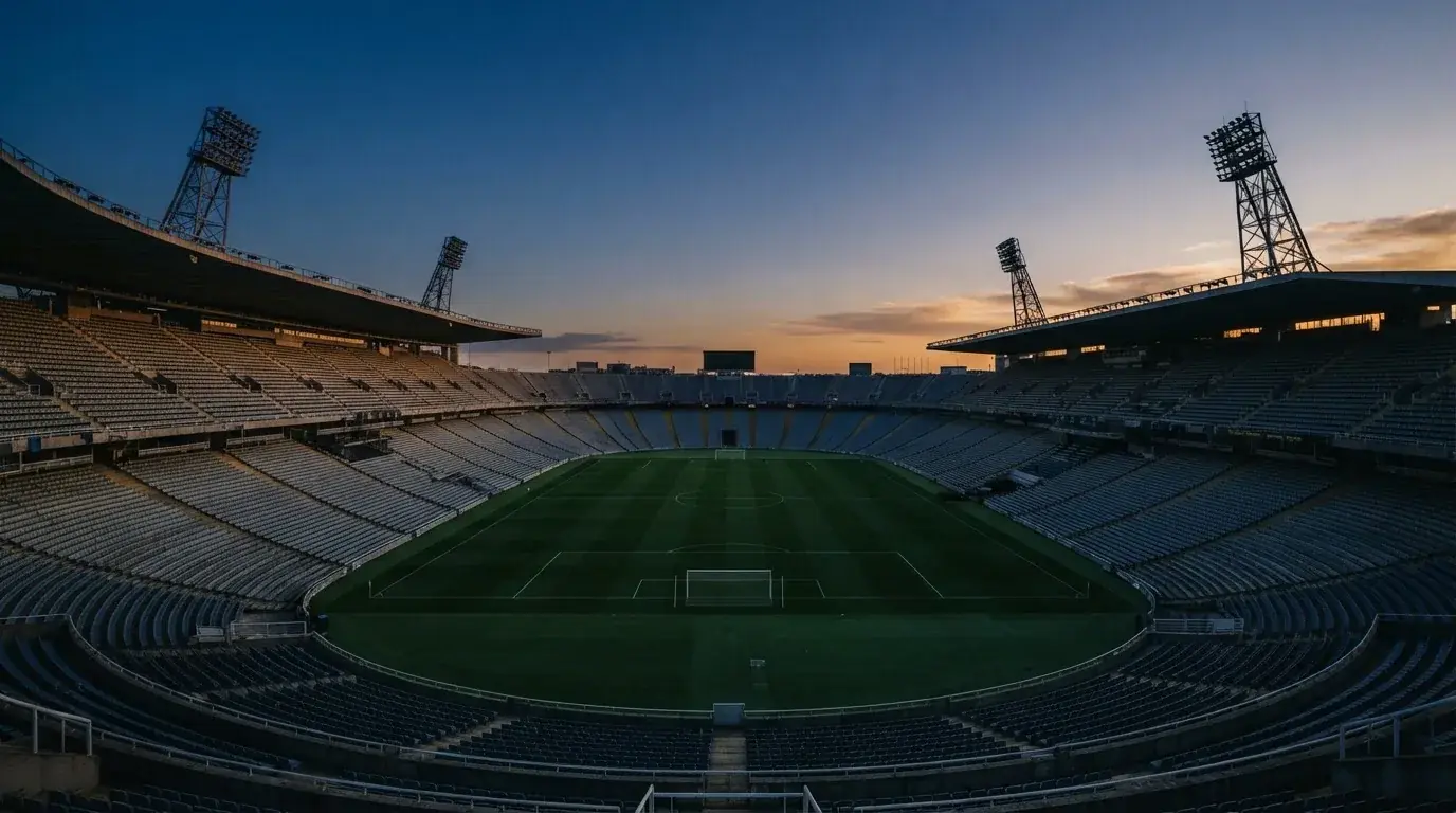 Een leeg voetbalstadion met lichtmasten bij schemering